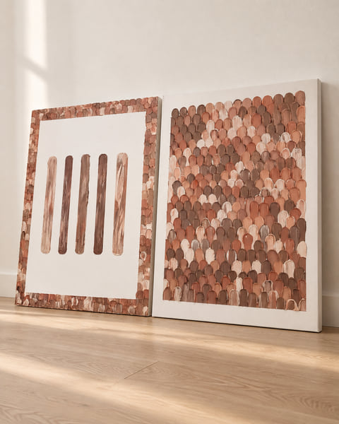 Two portrait canvases with terracotta, brown and burgundy scalloped texture, leaning against a wall on an oak floor
